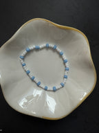 Armand mit weißen Perlen in verschiedenen Farben