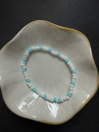 Armand mit weißen Perlen in verschiedenen Farben