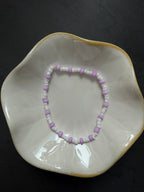 Armand mit weißen Perlen in verschiedenen Farben