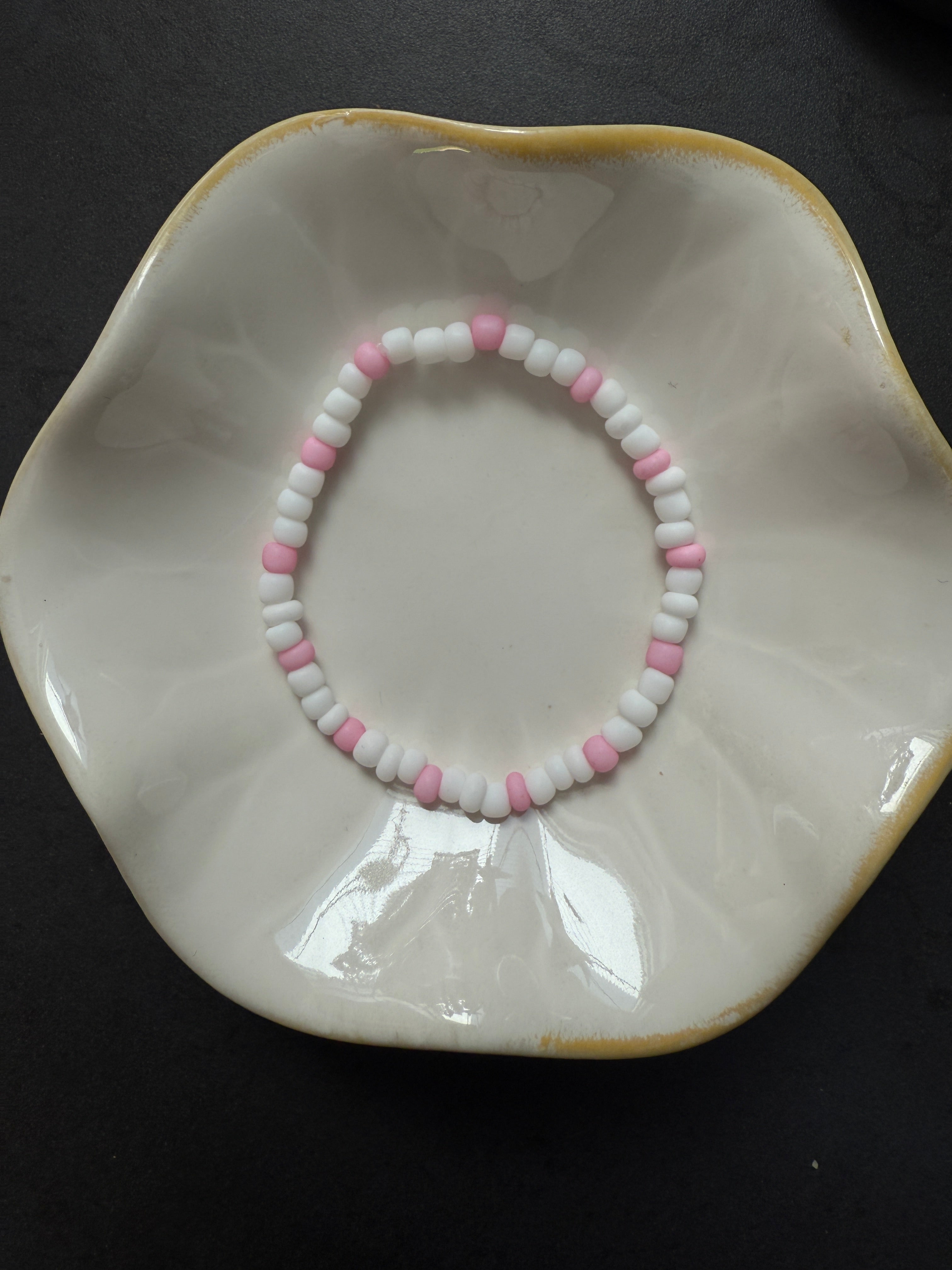 Armand mit weißen Perlen in verschiedenen Farben