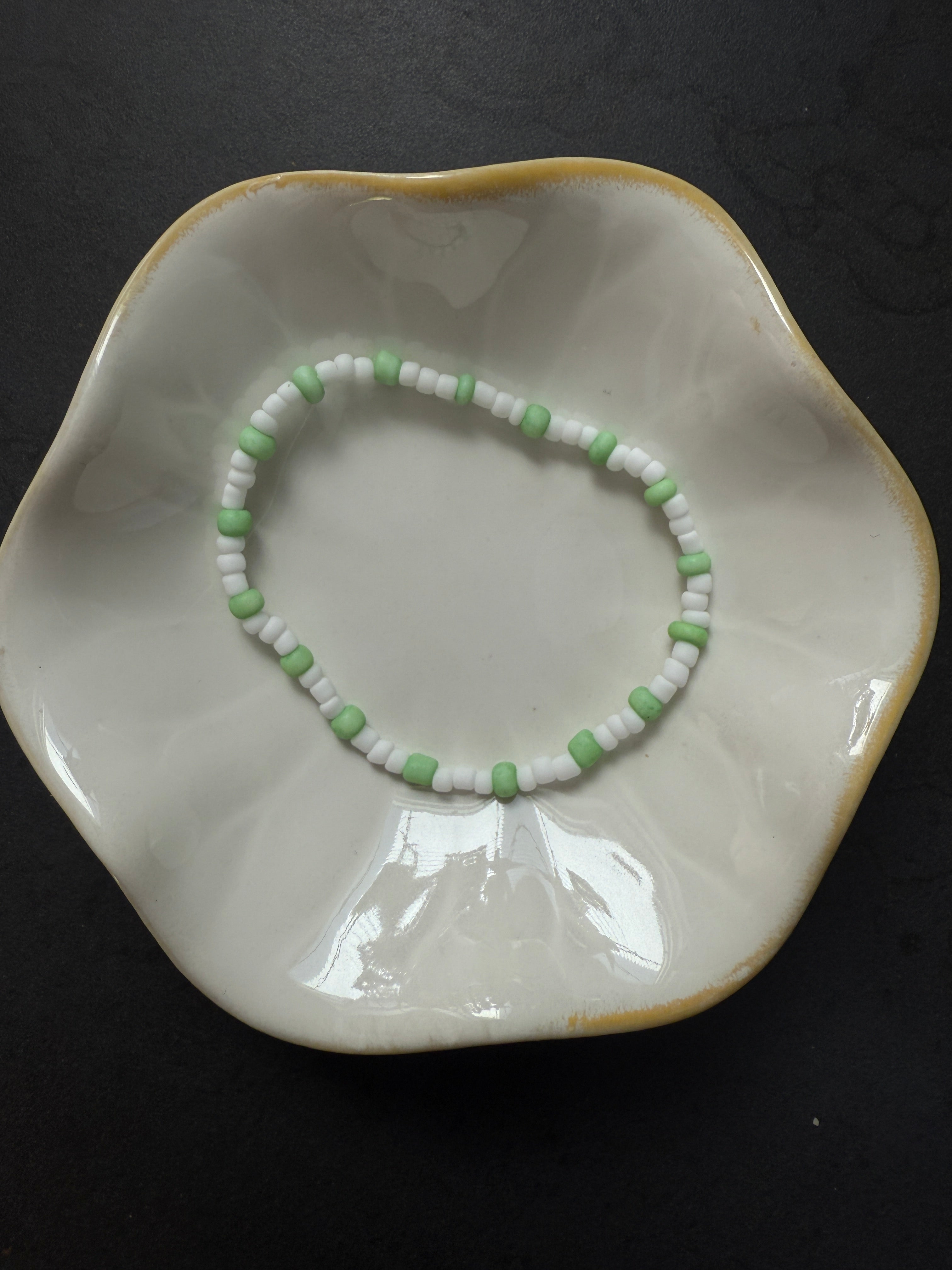 Armand mit weißen Perlen in verschiedenen Farben